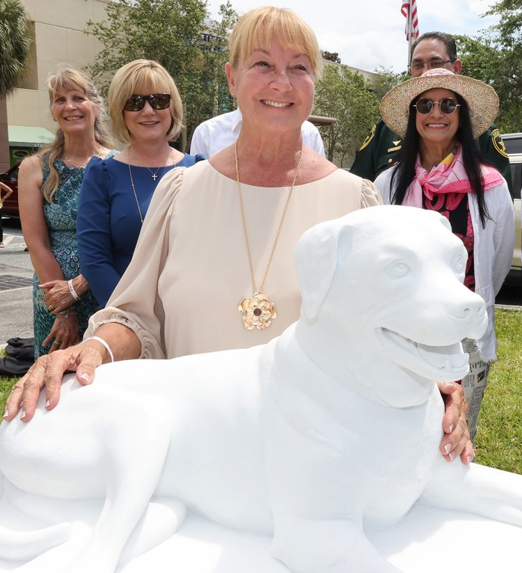 Lilly Baron, center, pets the marble statue of Molly, that Nilda Comas sculpted during the unveiling ceremony at the Citizens Service Center in downtown Ocala, Fla. on Wednesday, June 7, 2023. The late Molly was the ambassador of Molly's Law, the Animal Abuser Registry. The ordinance is named for Molly, an American Boxer mix, who was brutally stabbed and beaten with a wooden bat by Steven Scott Fleming in 2014. Lilly Baron, the SPCA of Ocala President adopted her. Nilda Comas created the marble statue from stone taken from the caves of Michelangelo in Italy. [Bruce Ackerman/Ocala Gazette] 2023.