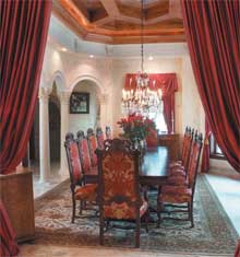 Lush red velvet  and a 12-seat mahagony table sets the dramatic tone for the dining room.