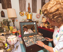 Owner Delores Carter examines a vintage box at her Umatilla Antiques Market.