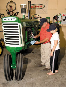 Michael and wife Jane check the oil in the now-restored Oliver tractor.