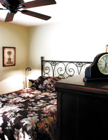 After: A wrought iron headboard and bedding give the master bedroom comfort and style.